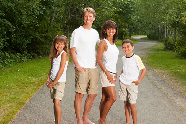 Dr. Jennifer Meader smiling with her husband and their two children outdoors